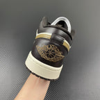 Heel of low-top sneakers in dark brown leather with gold winged emblem