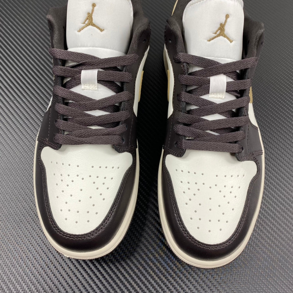 Pair of low-top sneakers with white toe boxes, dark brown uppers, and gold logos