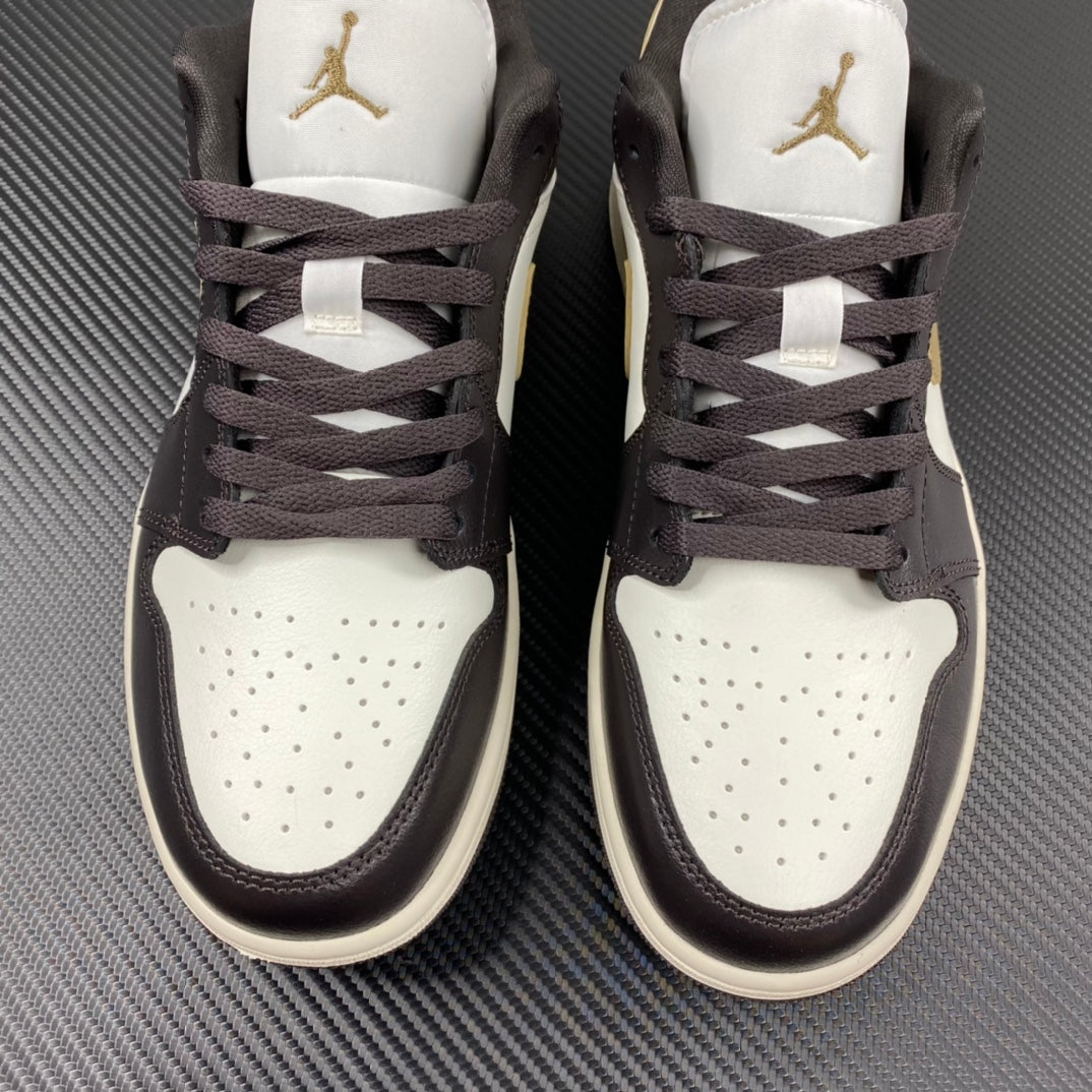 Pair of low-top sneakers with white toe boxes, dark brown uppers, and gold logos