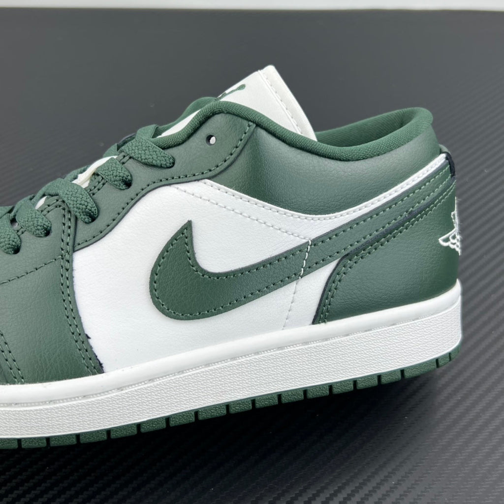 Low-top sneakers quarter close-up with dark green swoosh, white leather, and laces