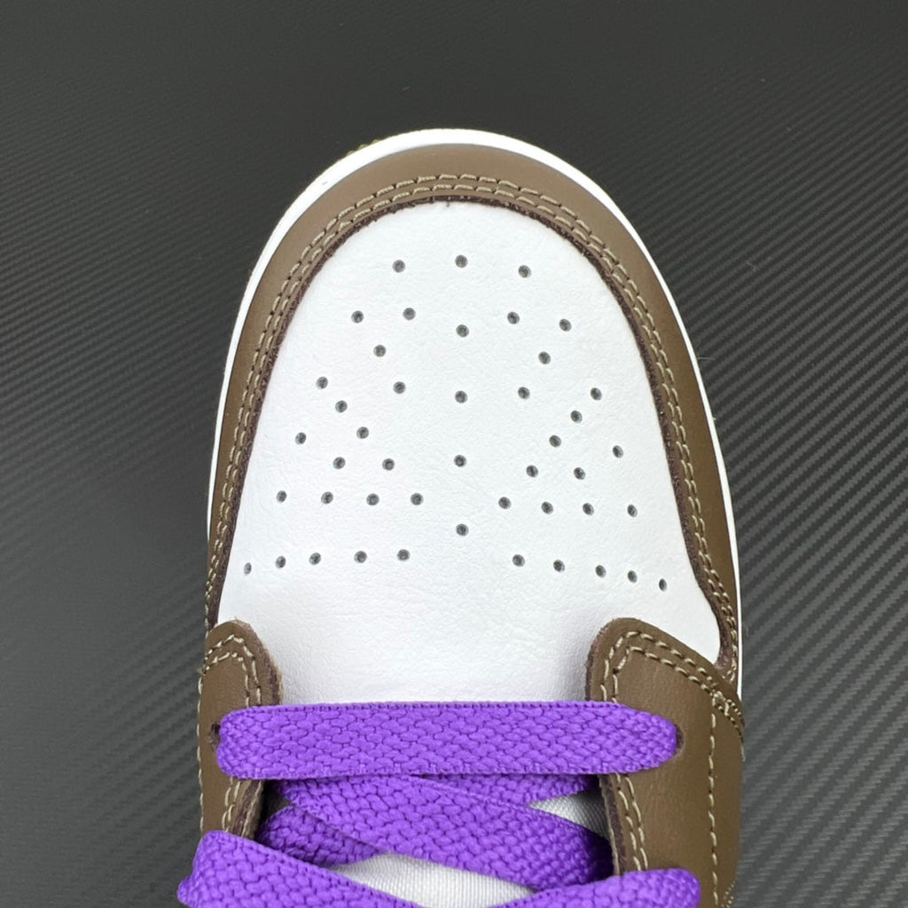 White perforated toe box with brown trim and purple lace strap on low-top sneaker