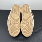 Low-top sneaker outsoles, textured tan rubber with circular traction patterns.