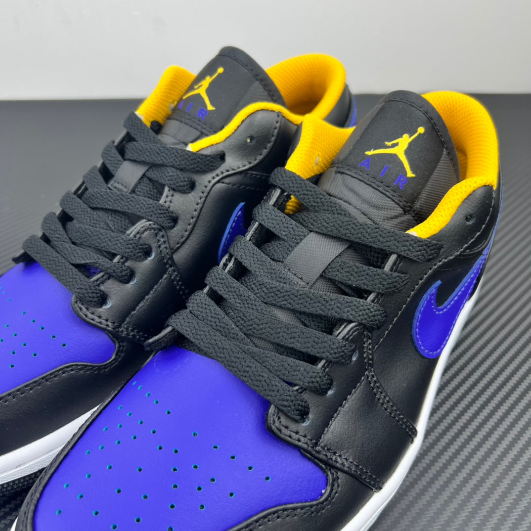 Low-top sneaker close-up with dark upper, purple accents, yellow collar lining, and gray laces.