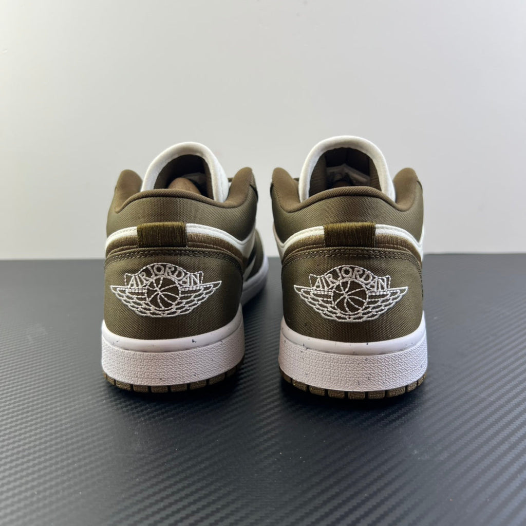 Back view of low-top sneakers in olive and white with winged logo on heel