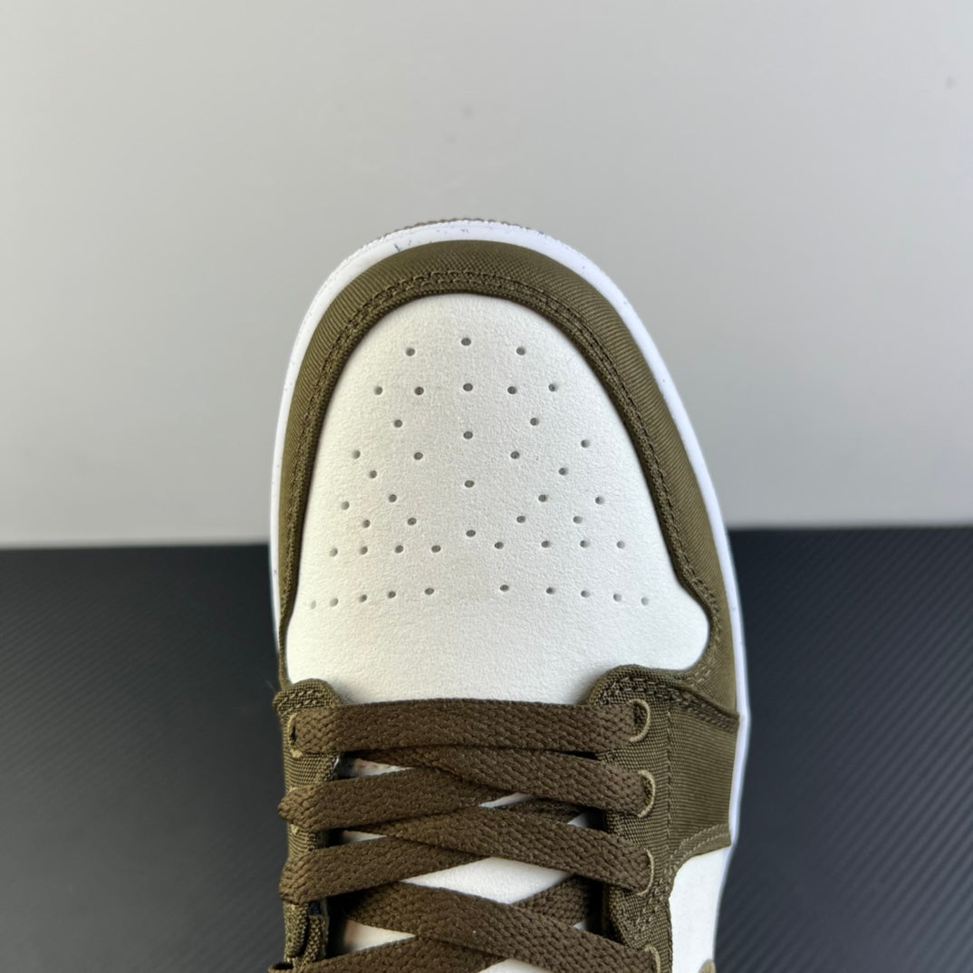 Close-up of low-top sneaker toe and laces in olive with perforated white panel