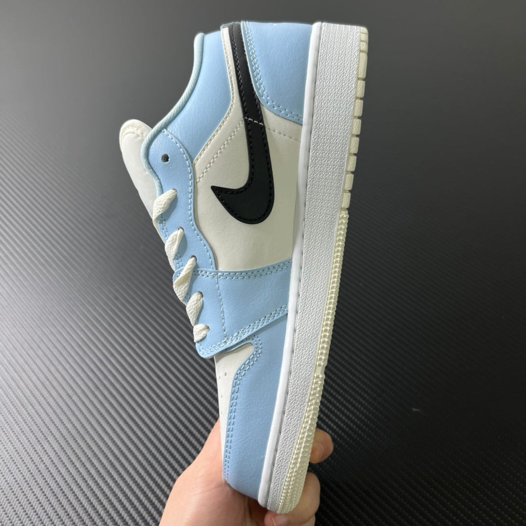 Air Jordan 1 Low sneaker side view held in hand, ice blue and white upper