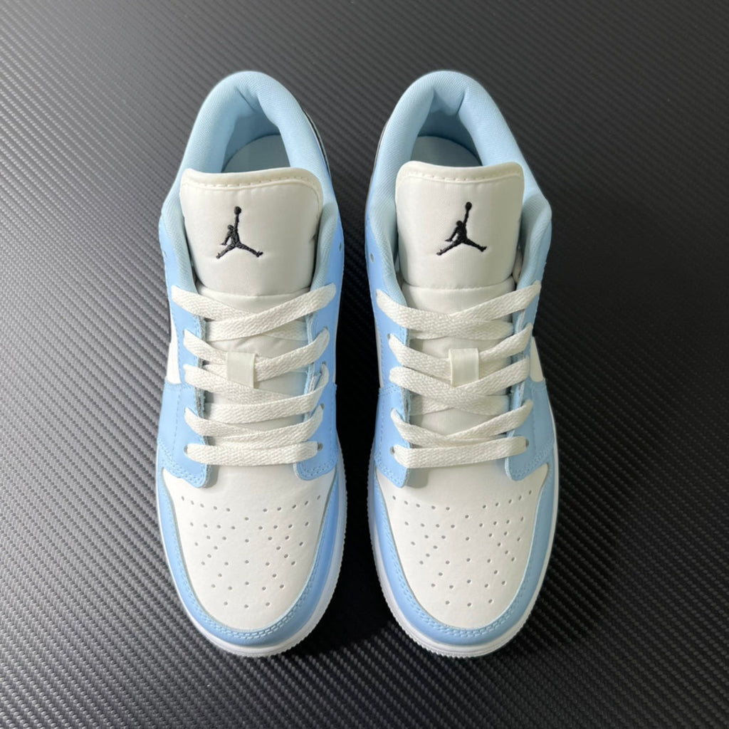 Air Jordan 1 Low pair with white uppers, light blue panels, and Jumpman on tongues
