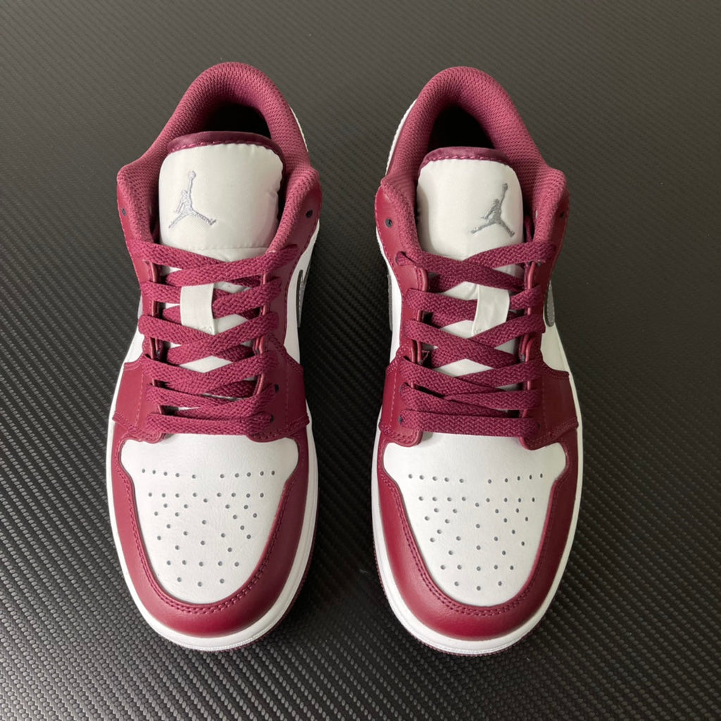 Pair of bordeaux and white Air Jordan low-top sneakers with lace-up and tongue logo