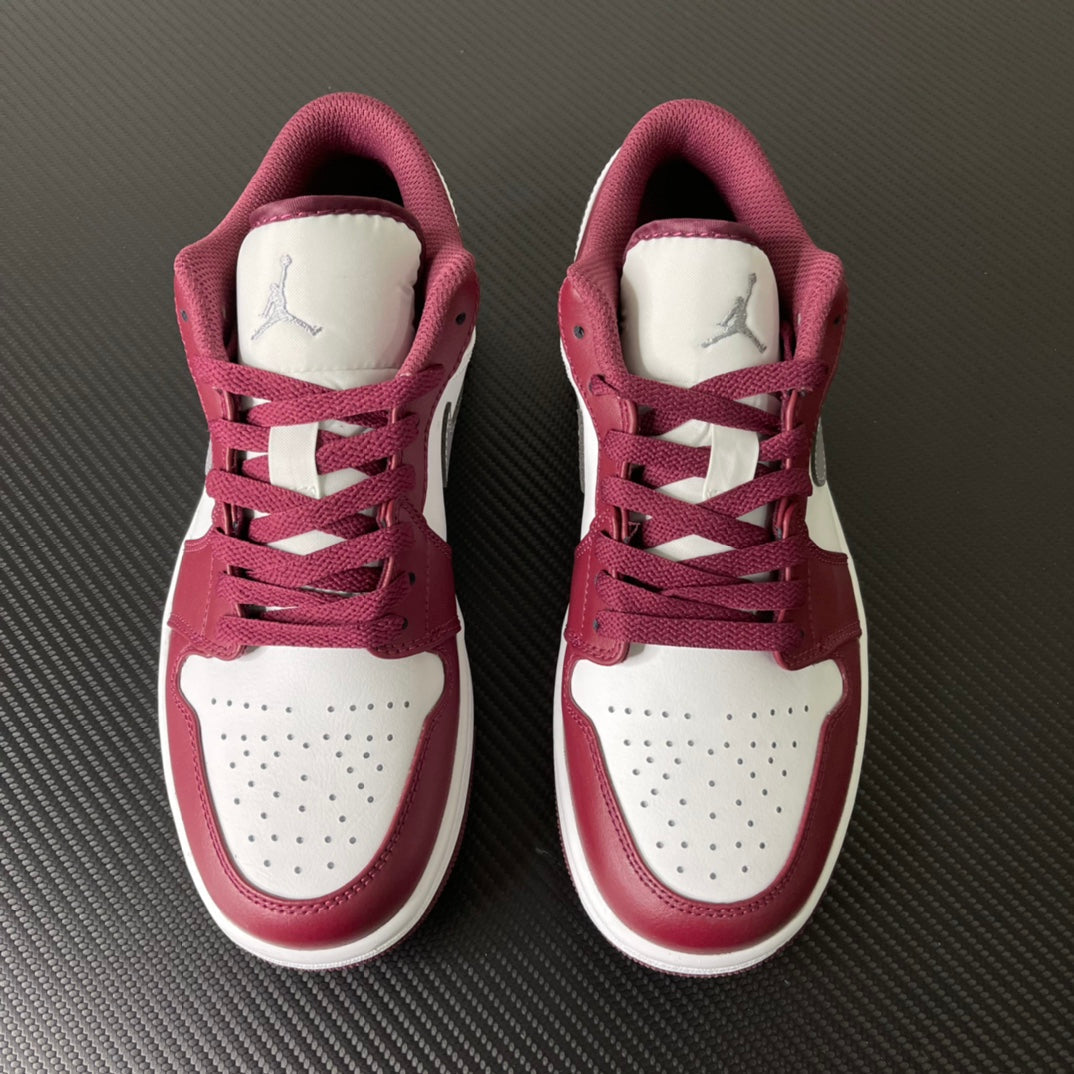 Pair of bordeaux and white Air Jordan low-top sneakers with lace-up and tongue logo