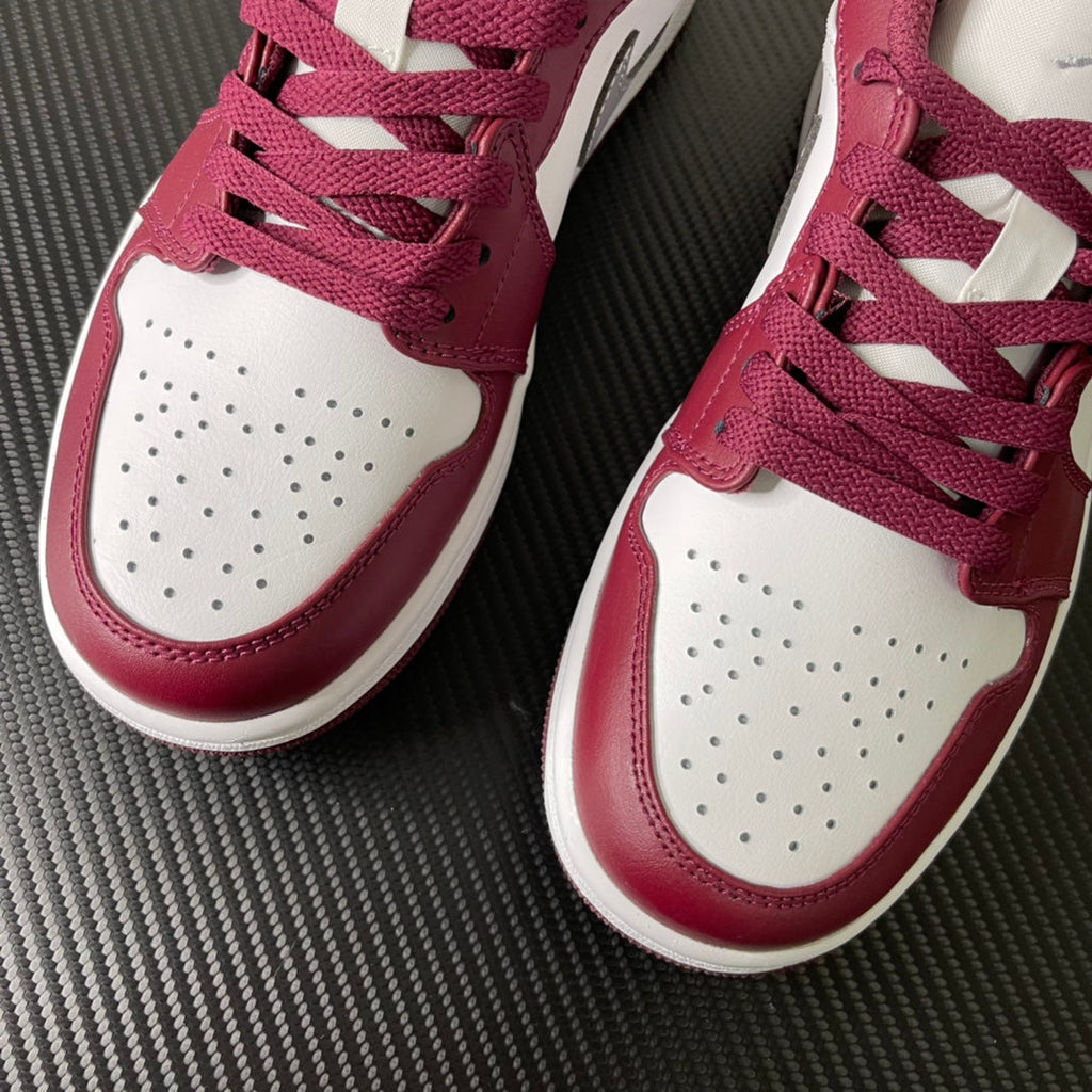 Pair of bordeaux and white low-top sneakers with perforated toe and lace-up front