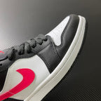 Black and white low-top sneakers with red swoosh and black lace-up