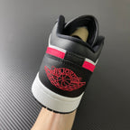 Black and white low-top sneakers with red heel logo on the back