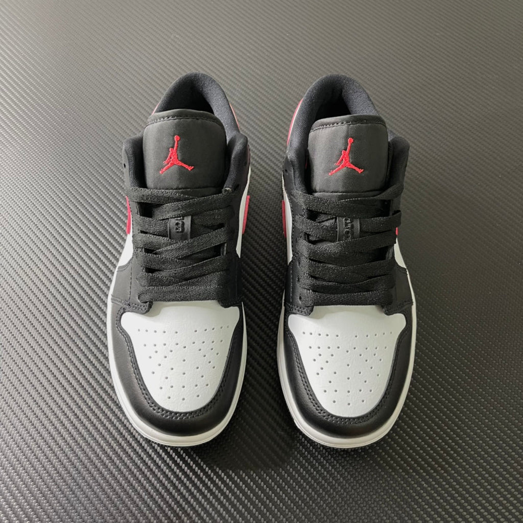 Pair of black and white low-top sneakers with red Air Jordan logos