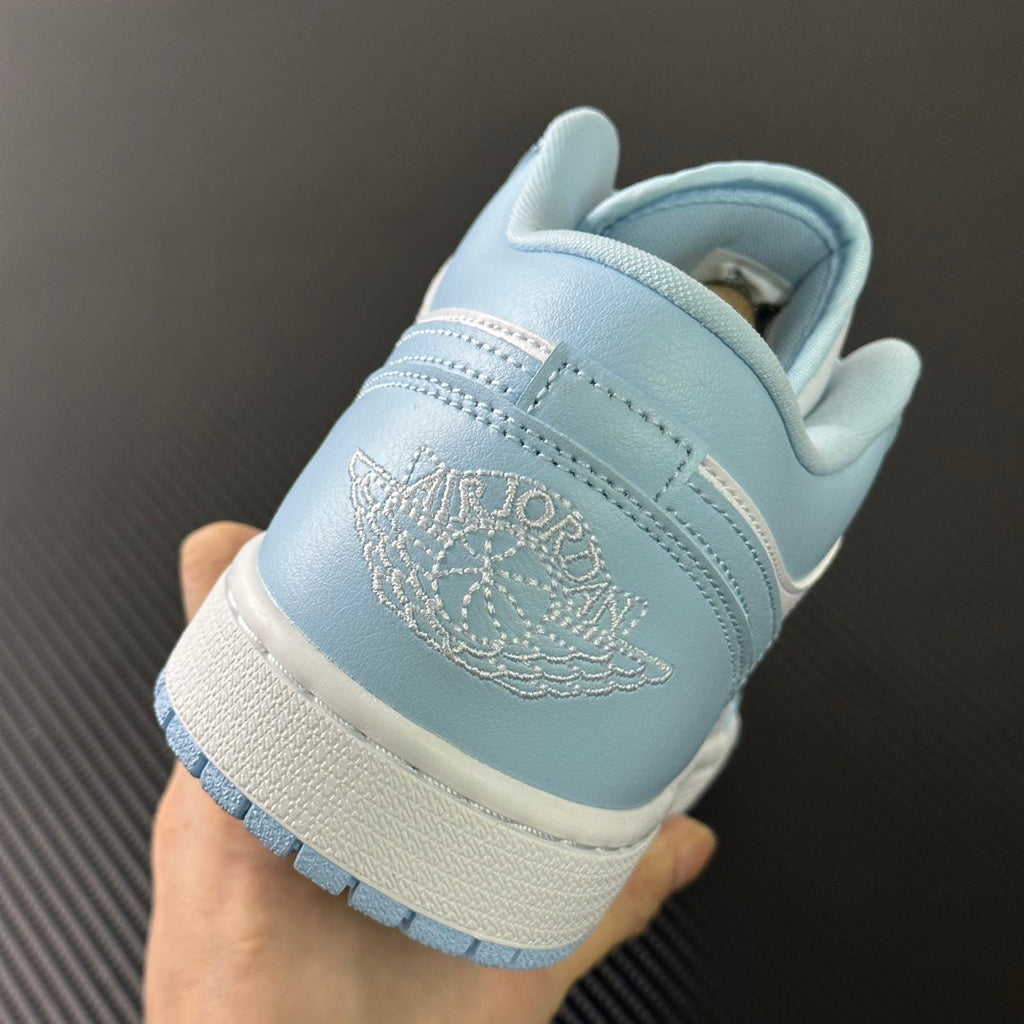 Light blue low-top sneakers with embroidered heel logo and cream midsole