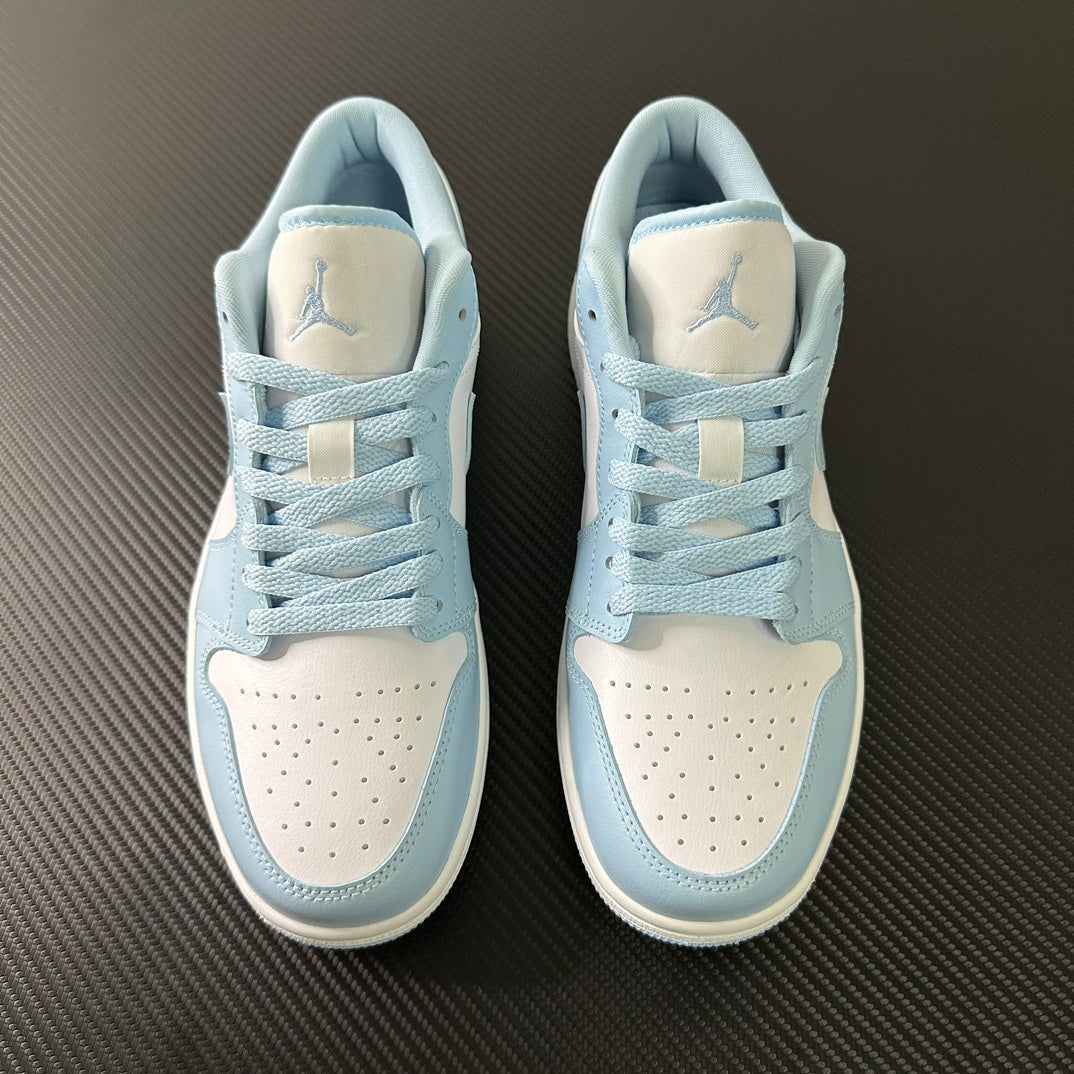 Pair of light blue and cream low-top sneakers with laces and perforated toe