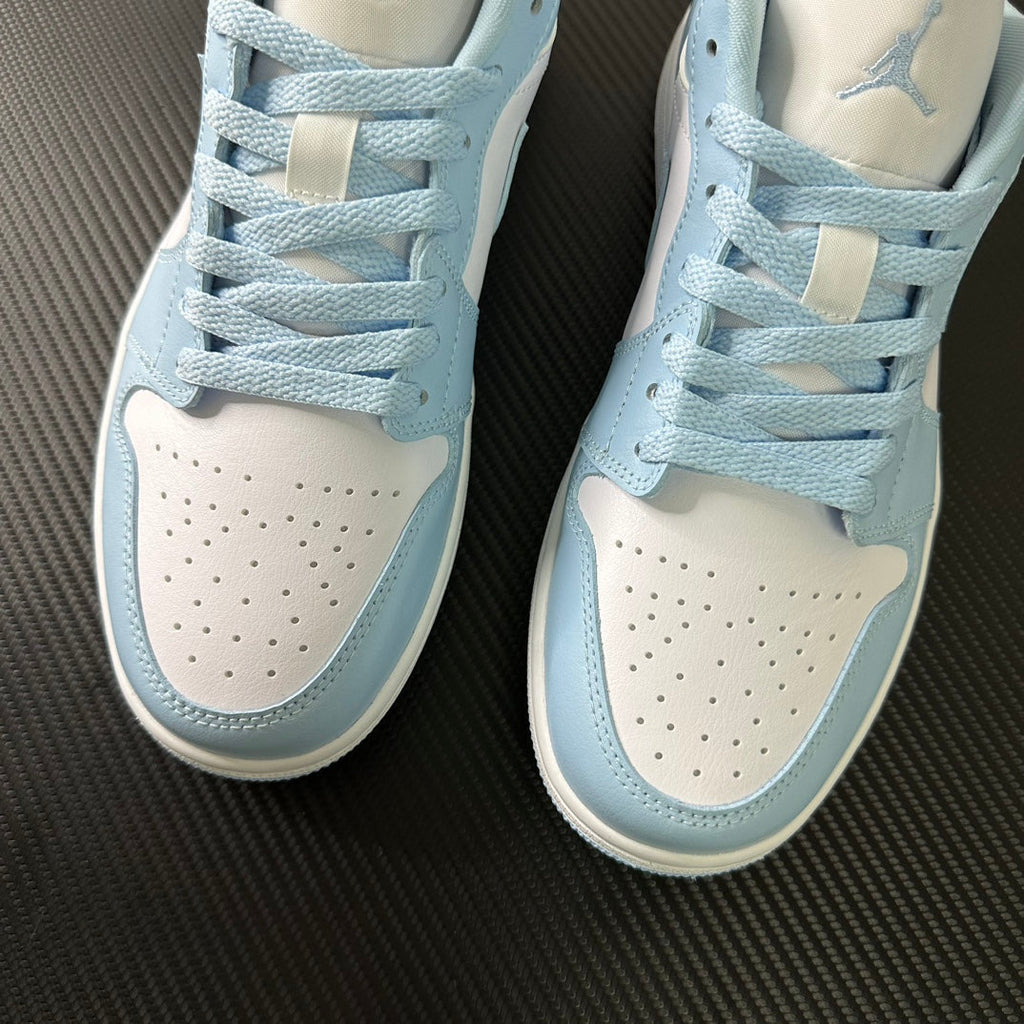 Light blue and cream low-top sneakers with lace-up front and perforated toe