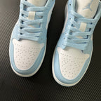 Light blue and cream low-top sneakers with lace-up front and perforated toe