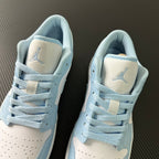 Pair of light blue and cream low-top sneakers with heel tabs and laces