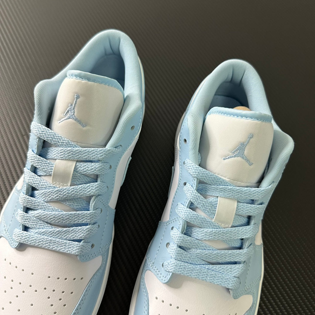 Pair of light blue and cream low-top sneakers with heel tabs and laces