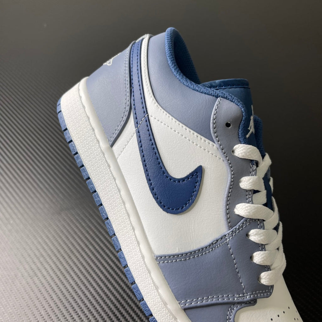 Low-top sneakers quarter view with light blue trim, white laces, and stitched swoosh