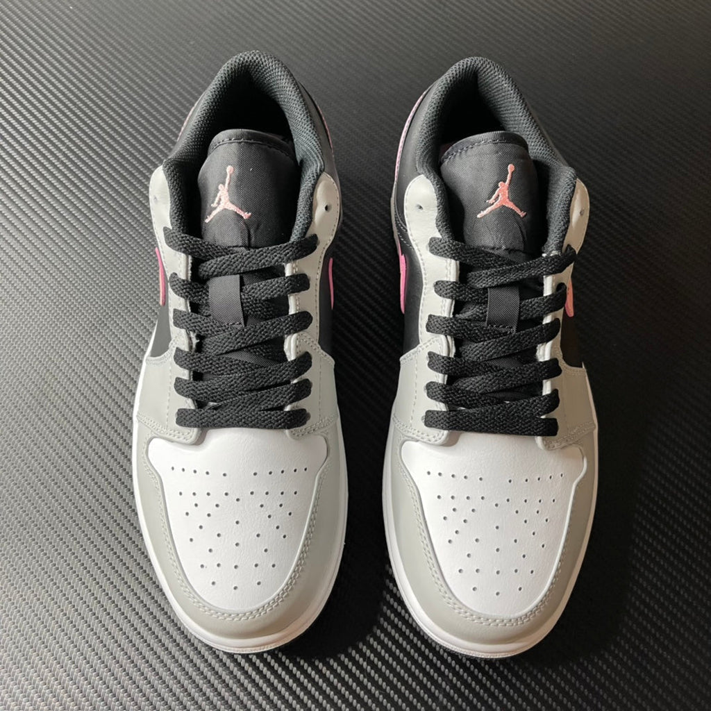 Pair of low-top Air Jordan 1 sneakers, white uppers with black laces and gray heel