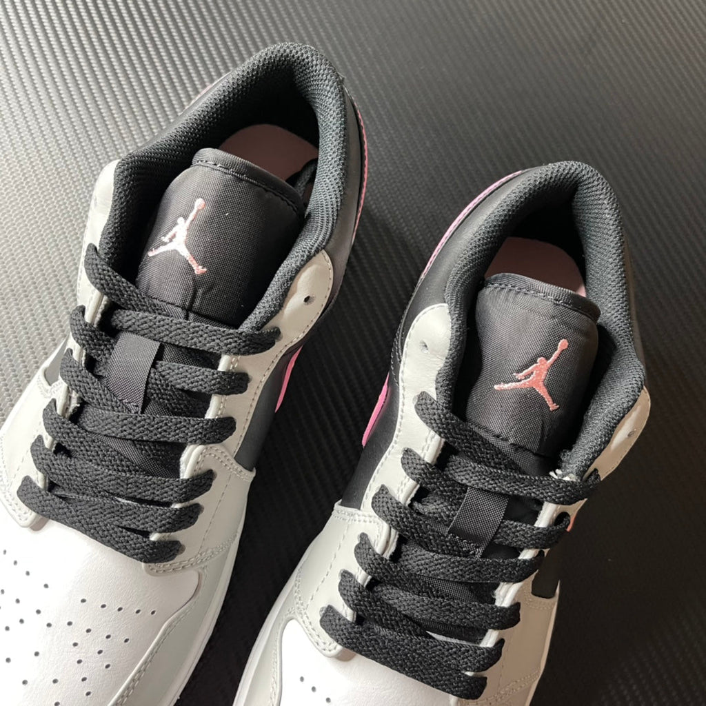 Pair of low-top Air Jordan 1 sneakers, black tongue with pink Jumpman and white sides