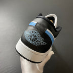 Low-top sneakers heel view with black heel panel, white trim, and light blue Jumpman logo.