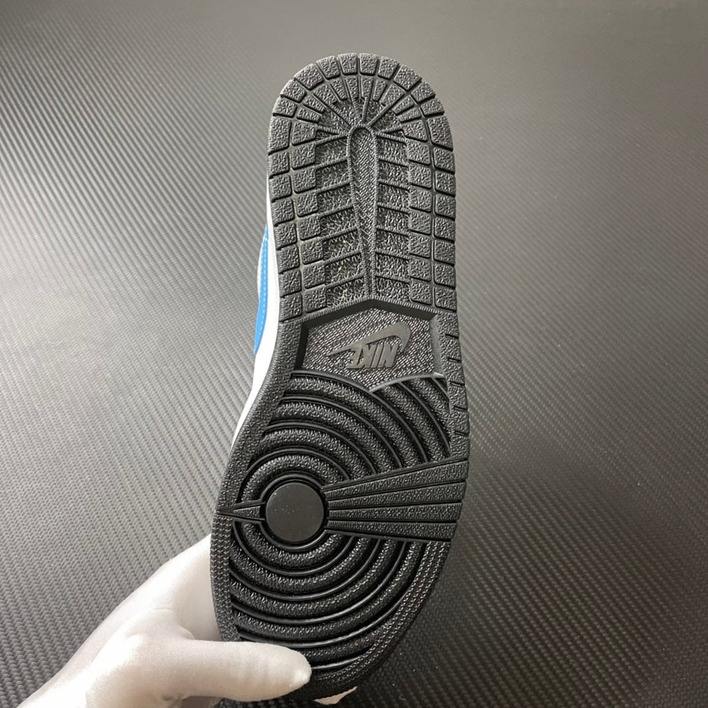 Shoe outsole close-up with textured rubber tread and light blue accent on the side.