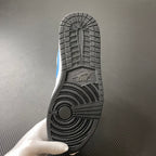 Shoe outsole close-up with textured rubber tread and light blue accent on the side.