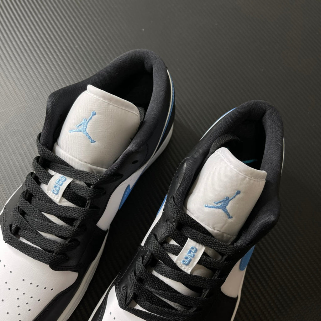 Pair of low-top sneakers showing tongues and heel counters with black laces and light blue Jumpman.