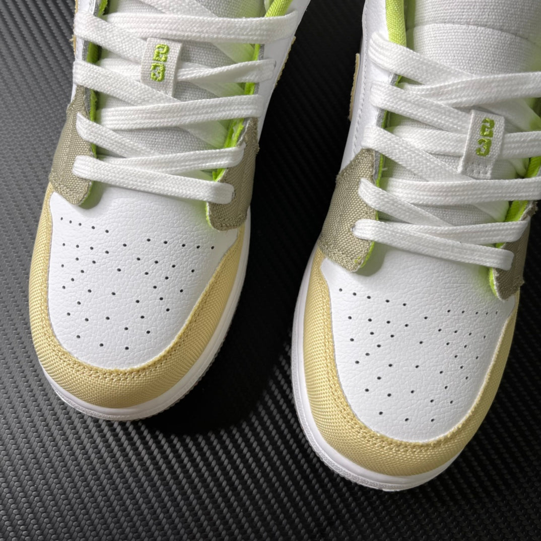 Low-top sneaker front with perforated white leather and neon green lace accents