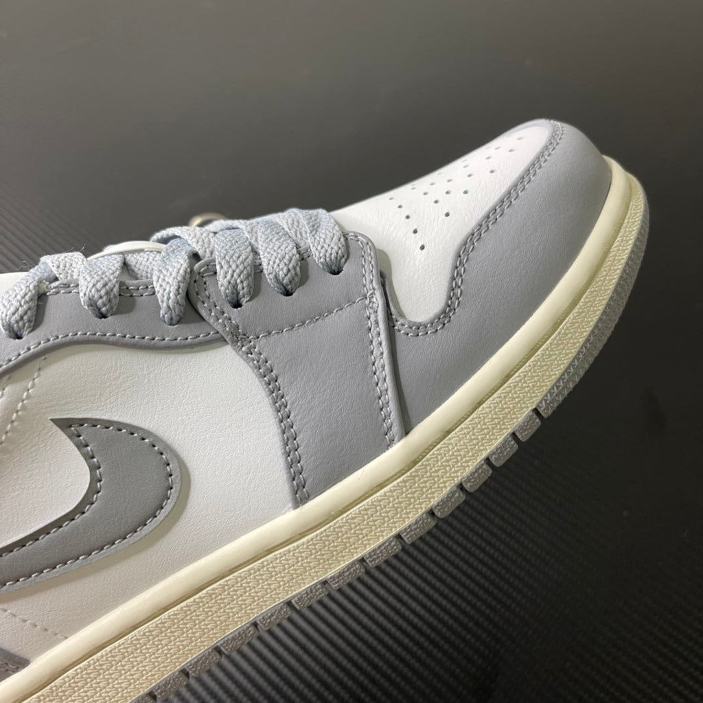Low-top sneakers side view, light gray laces, white leather with stitched overlays