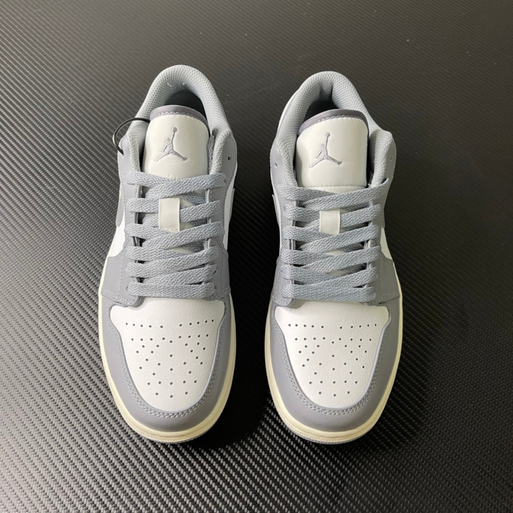 Low-top sneakers pair, white uppers with gray laces and padded tongue