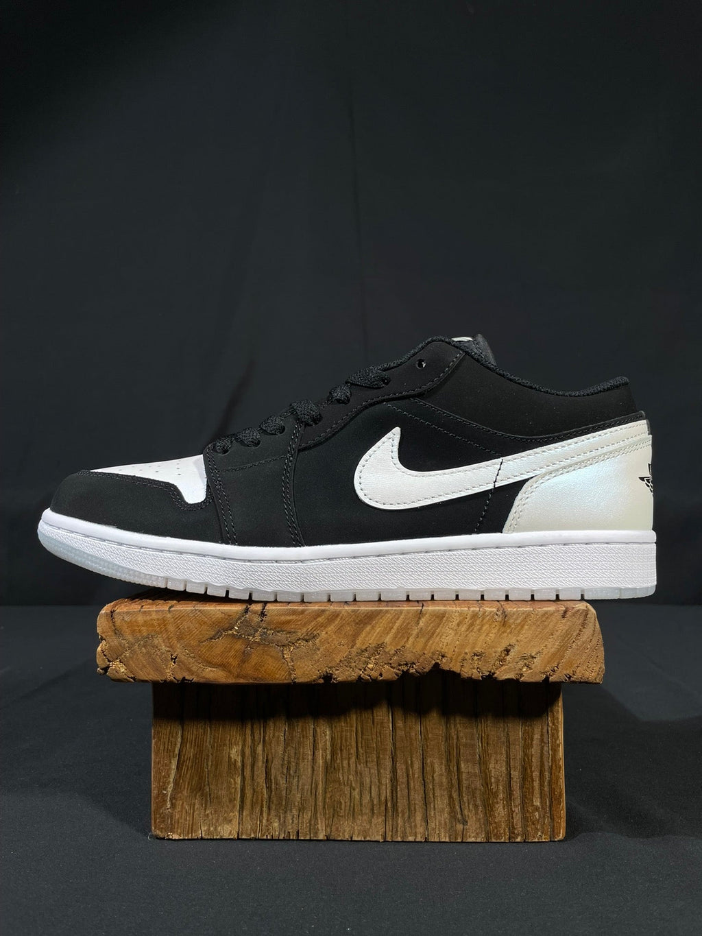 Black and white low-top sneakers with Nike swoosh, lace-up front, white midsole