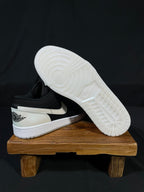 Black and white low-top sneaker showing white outsole tread and side profile