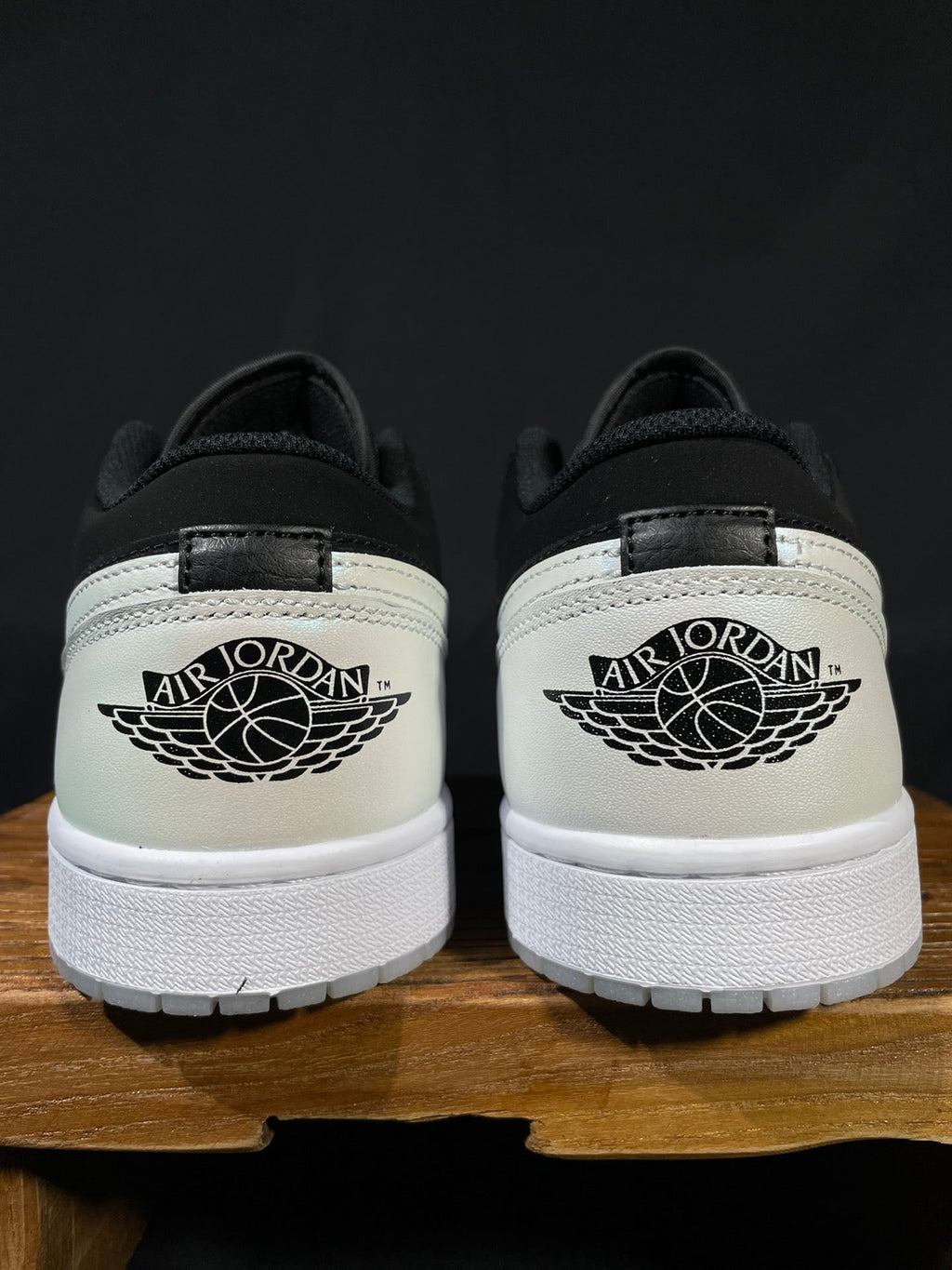 Back view of black and white low-top sneakers with Air Jordan wing logo on heel