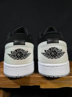 Back view of black and white low-top sneakers with Air Jordan wing logo on heel