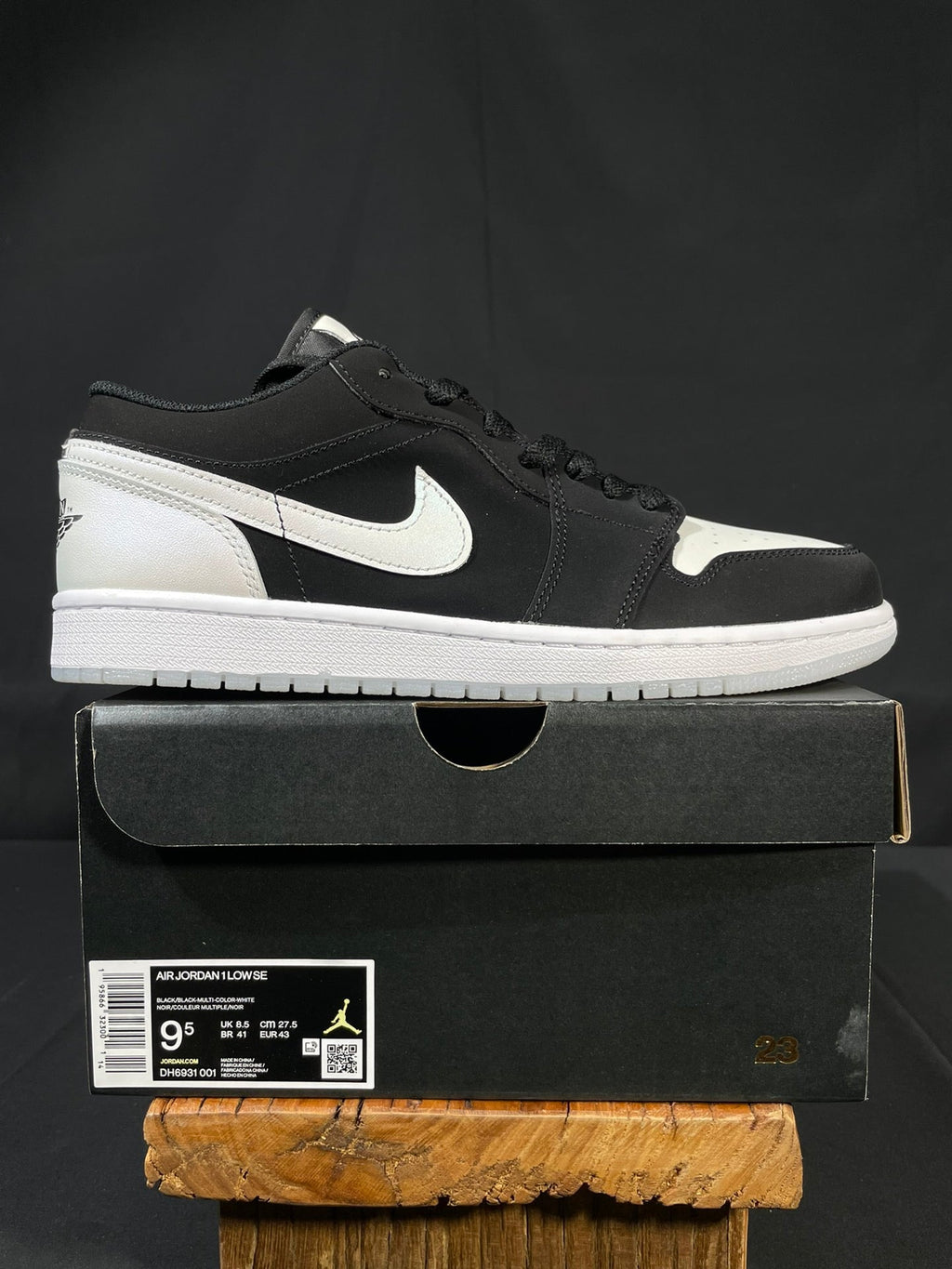 Black and white low-top sneakers with Nike swoosh and lace-up front on shoebox