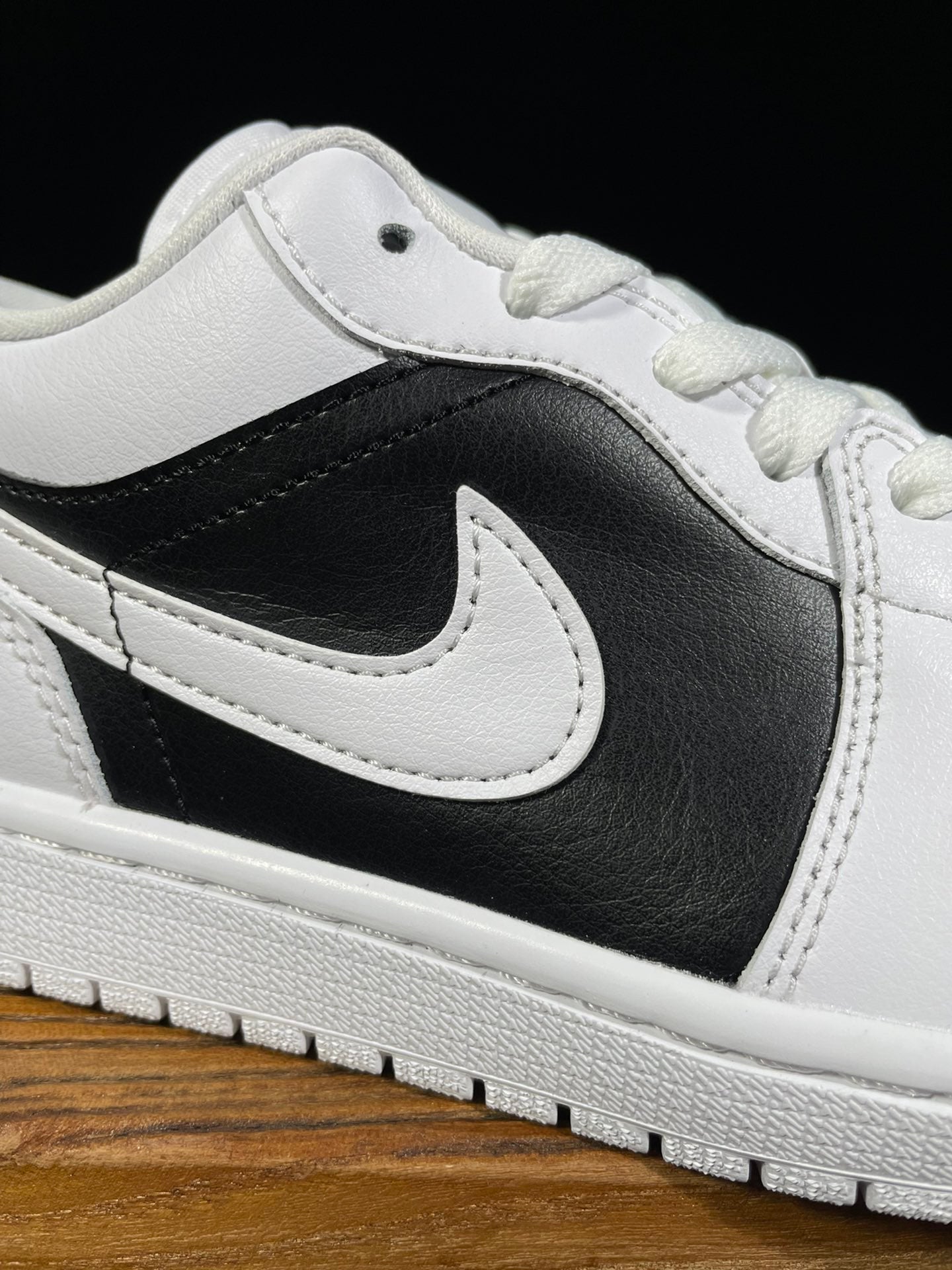 Air Jordan 1 Low shoe upper with black swoosh and white stitched panels