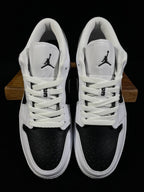 Air Jordan 1 Low sneakers with white laces, black toe panels, Jordan tongue logos
