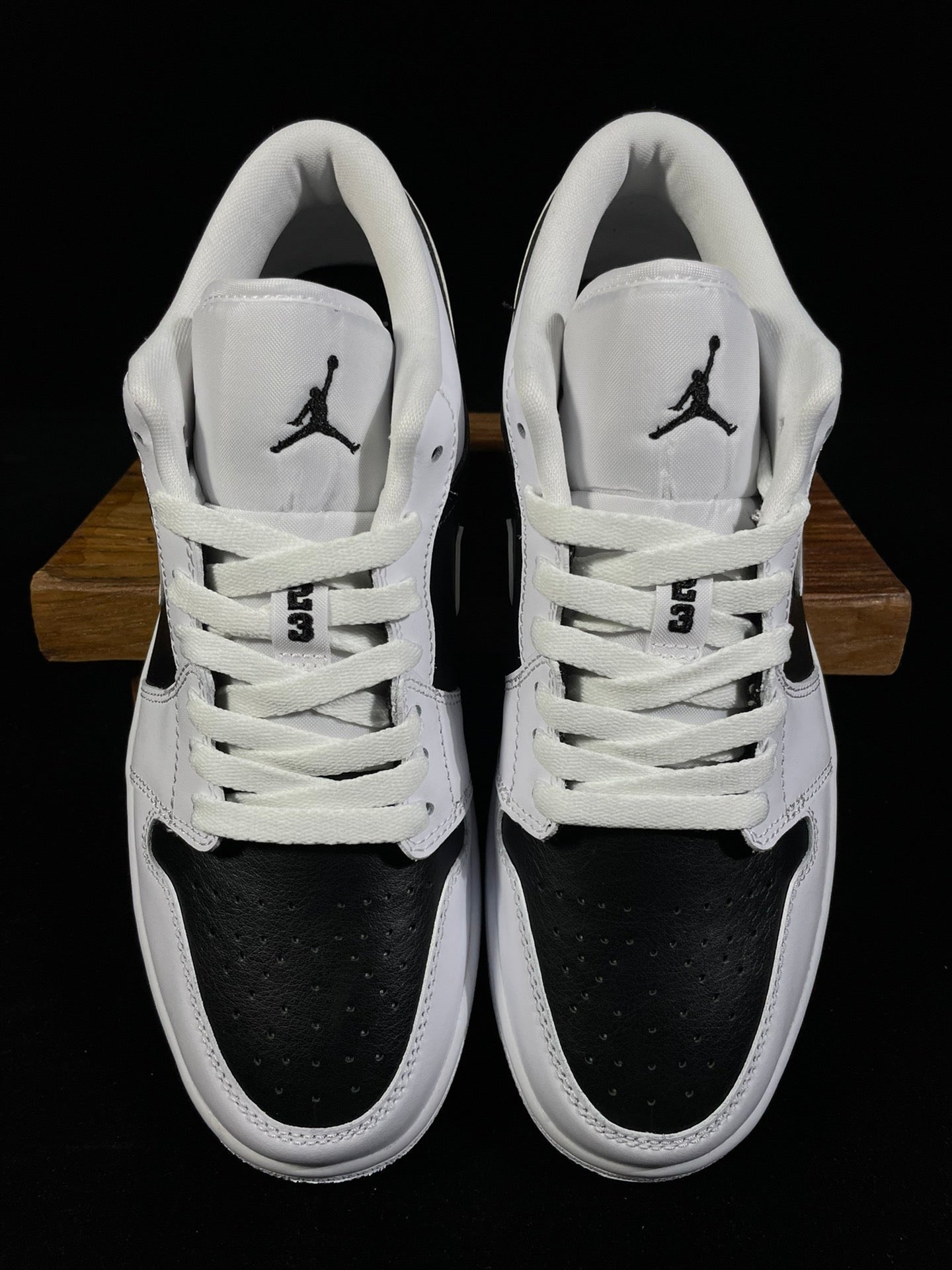 Air Jordan 1 Low sneakers with white laces, black toe panels, Jordan tongue logos