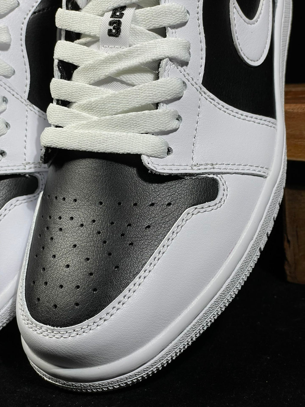 Air Jordan 1 Low sneaker toe box and laces with white leather perforations