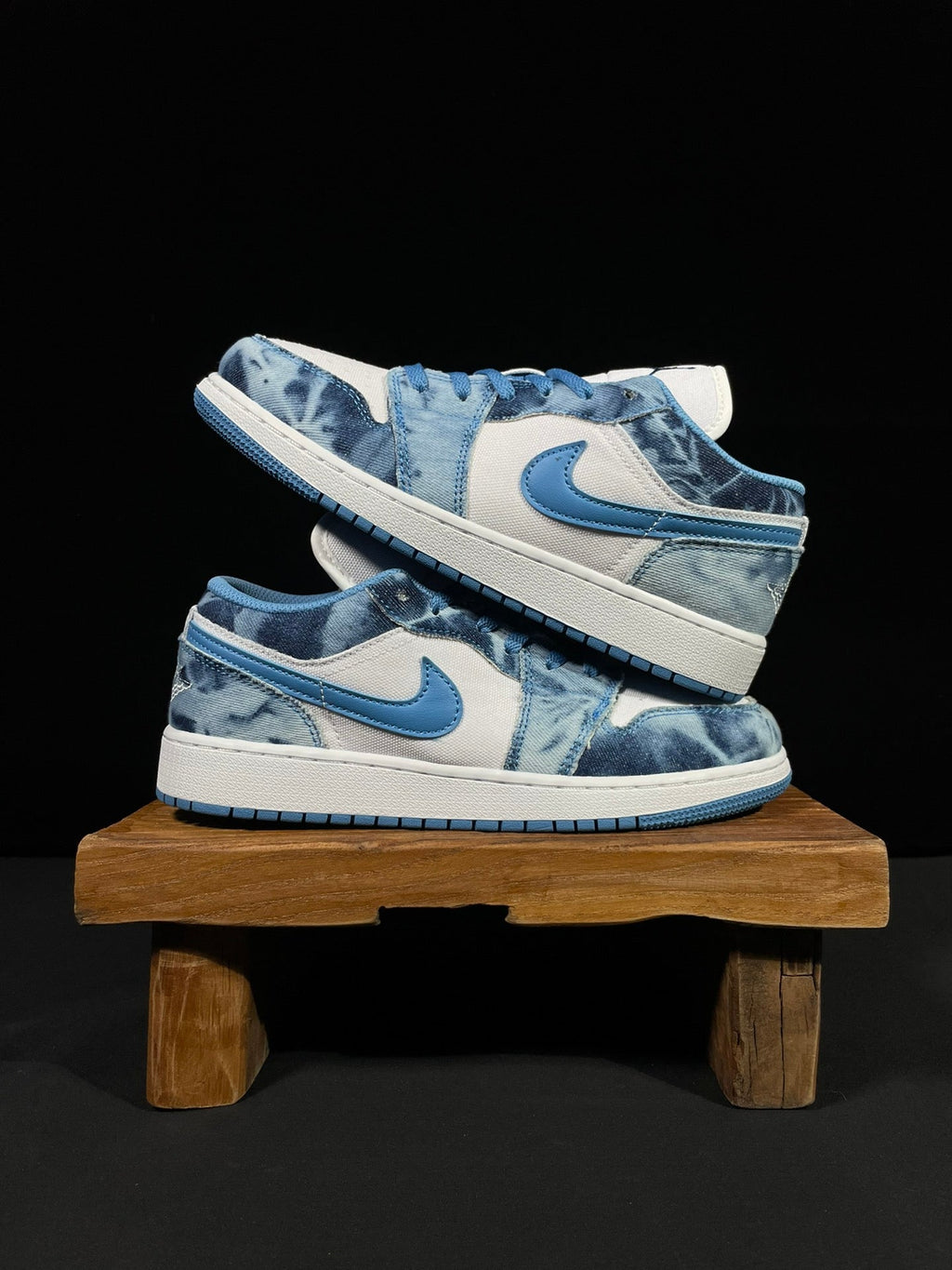Air Jordan 1 Low sneaker pair with blue laces and washed denim panels