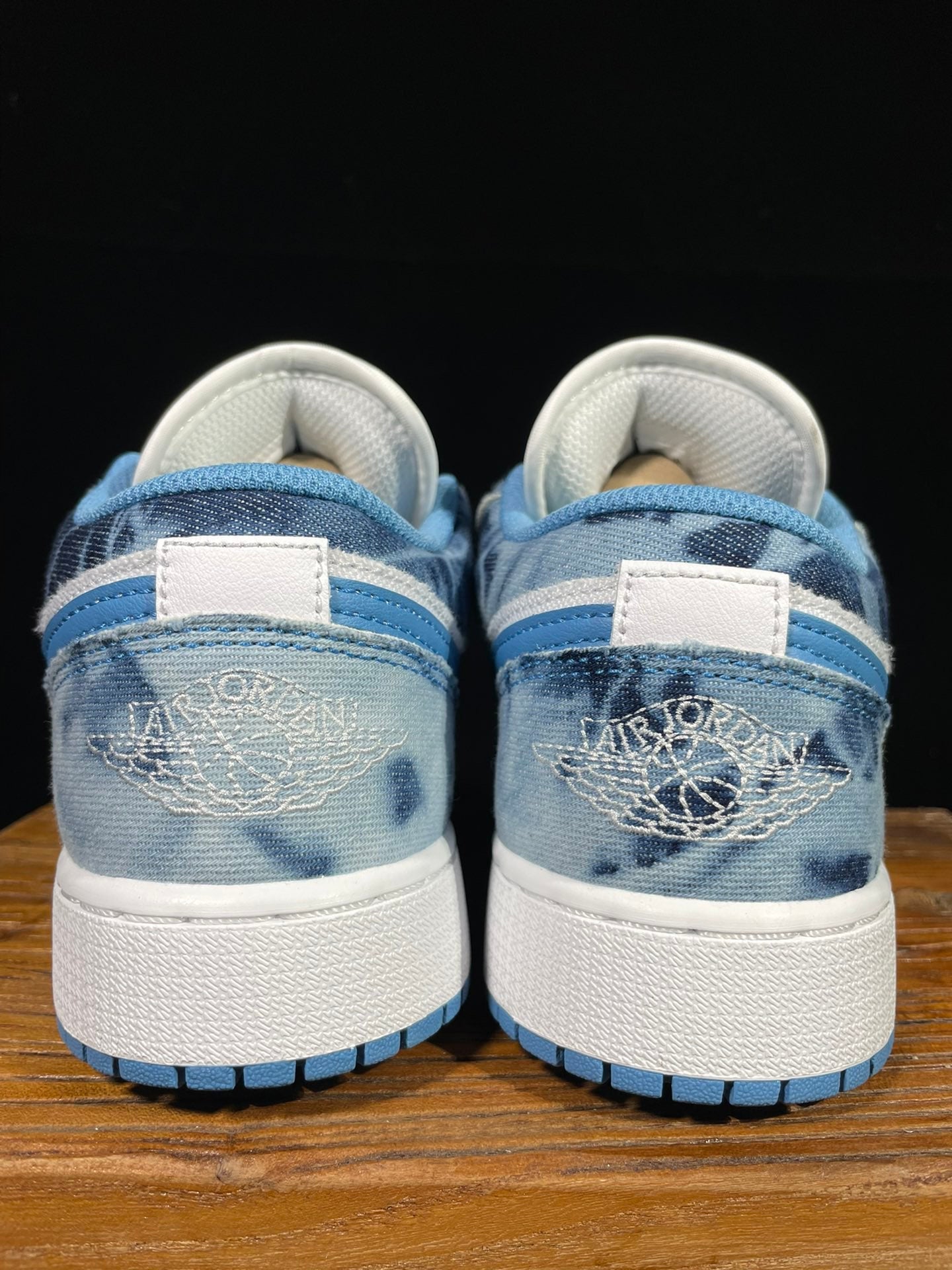 Air Jordan 1 Low sneaker back view with blue heel and woven ankle collar