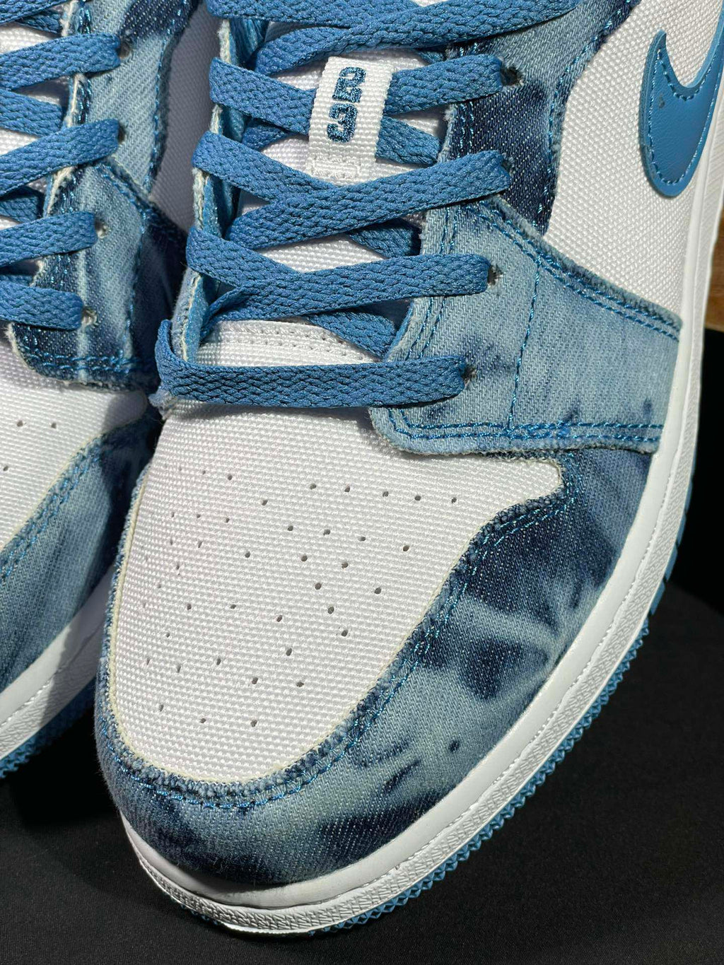 Air Jordan 1 Low sneaker close-up of laces, denim collar, and stitching