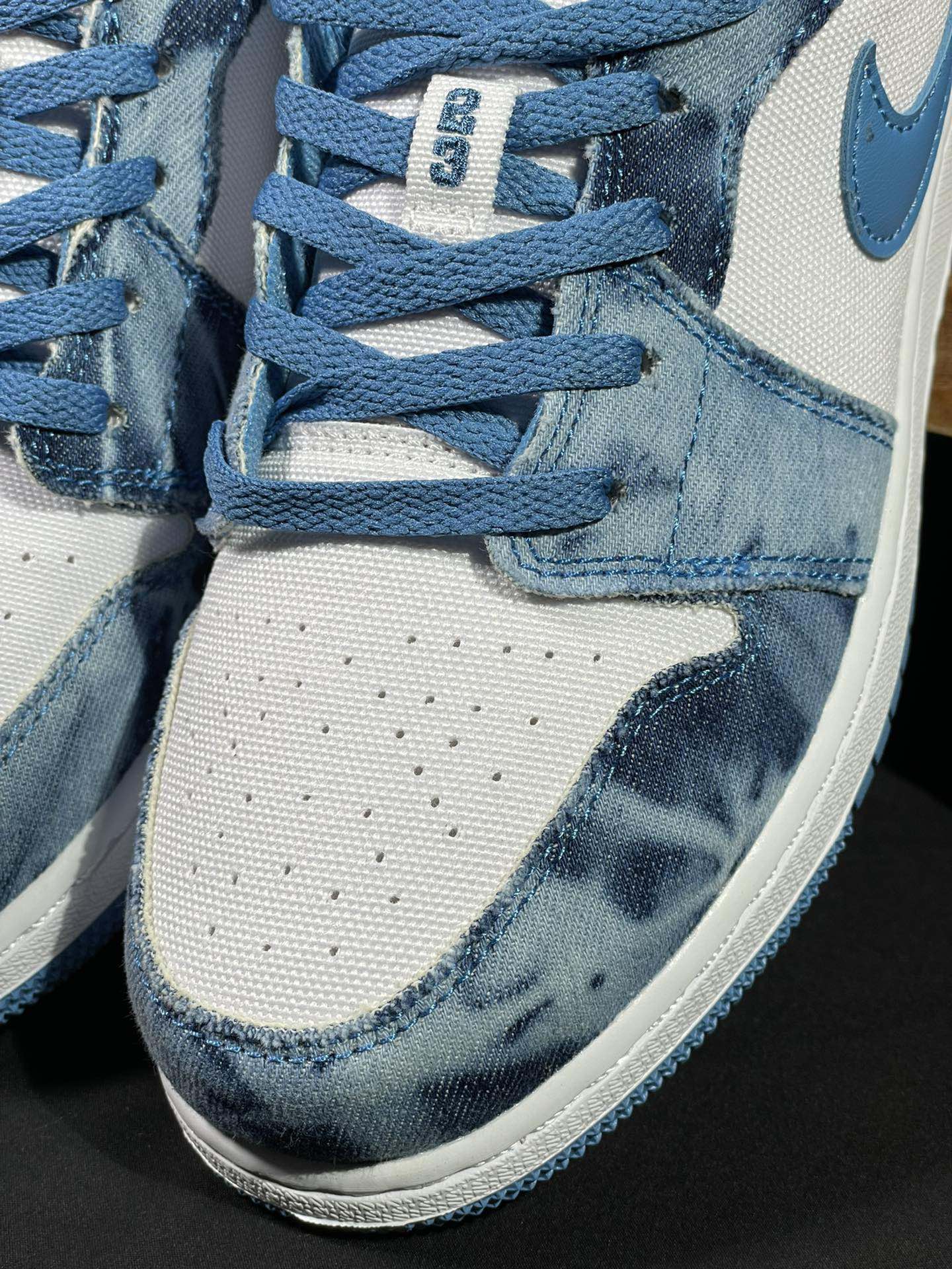 Air Jordan 1 Low sneaker close-up of laces, denim collar, and stitching