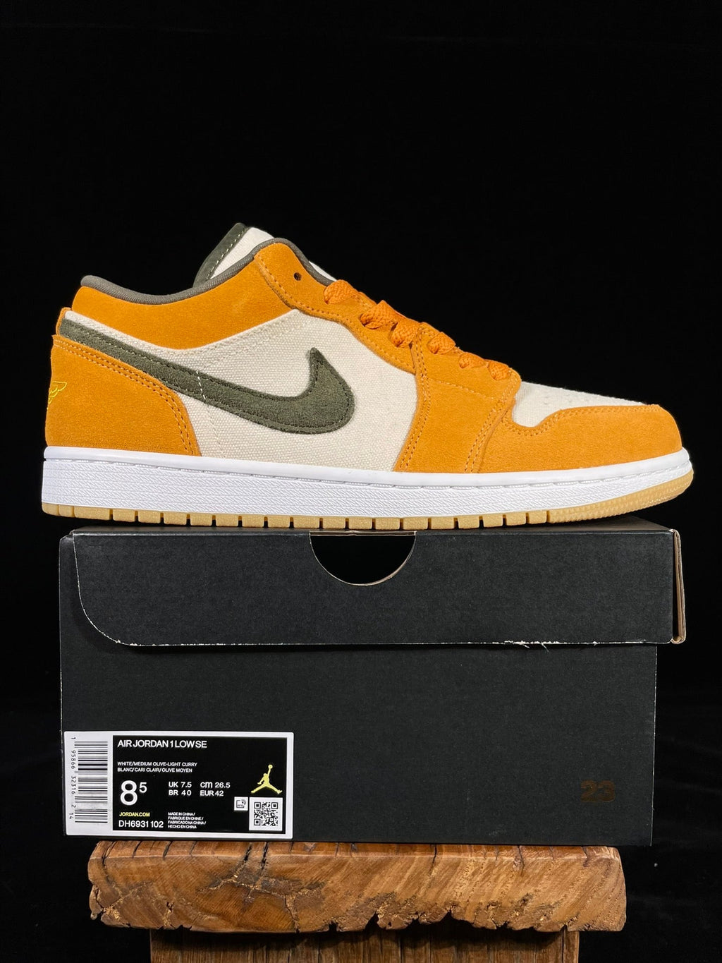 Orange, white and olive low-top sneakers with Nike swoosh, shown with shoebox.