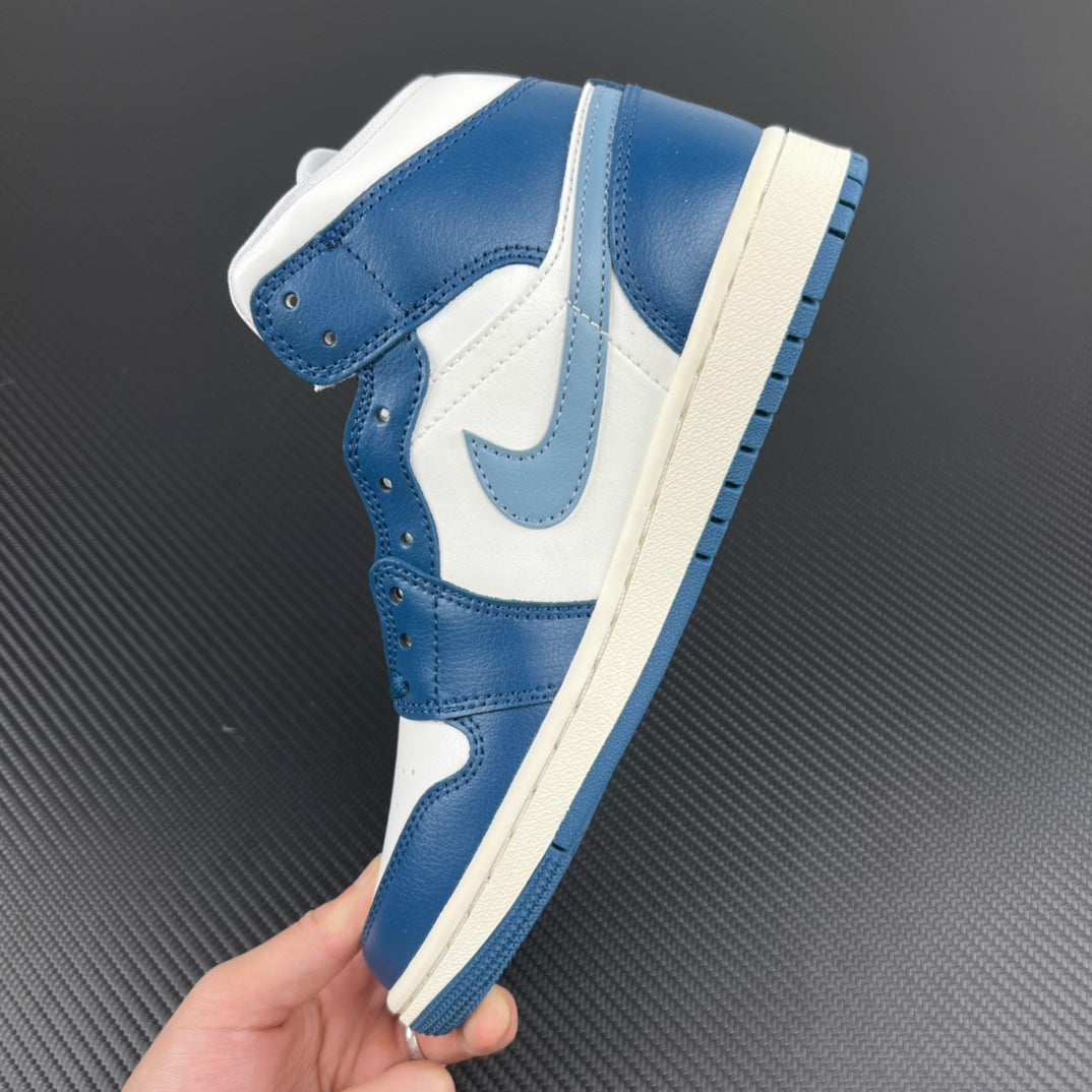 Mid-top sneaker held in hand, showing white and blue color blocking and side panels.