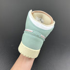 Air Jordan 1 Mid sneaker heel view with mint collar, white lining, and pale yellow platform sole