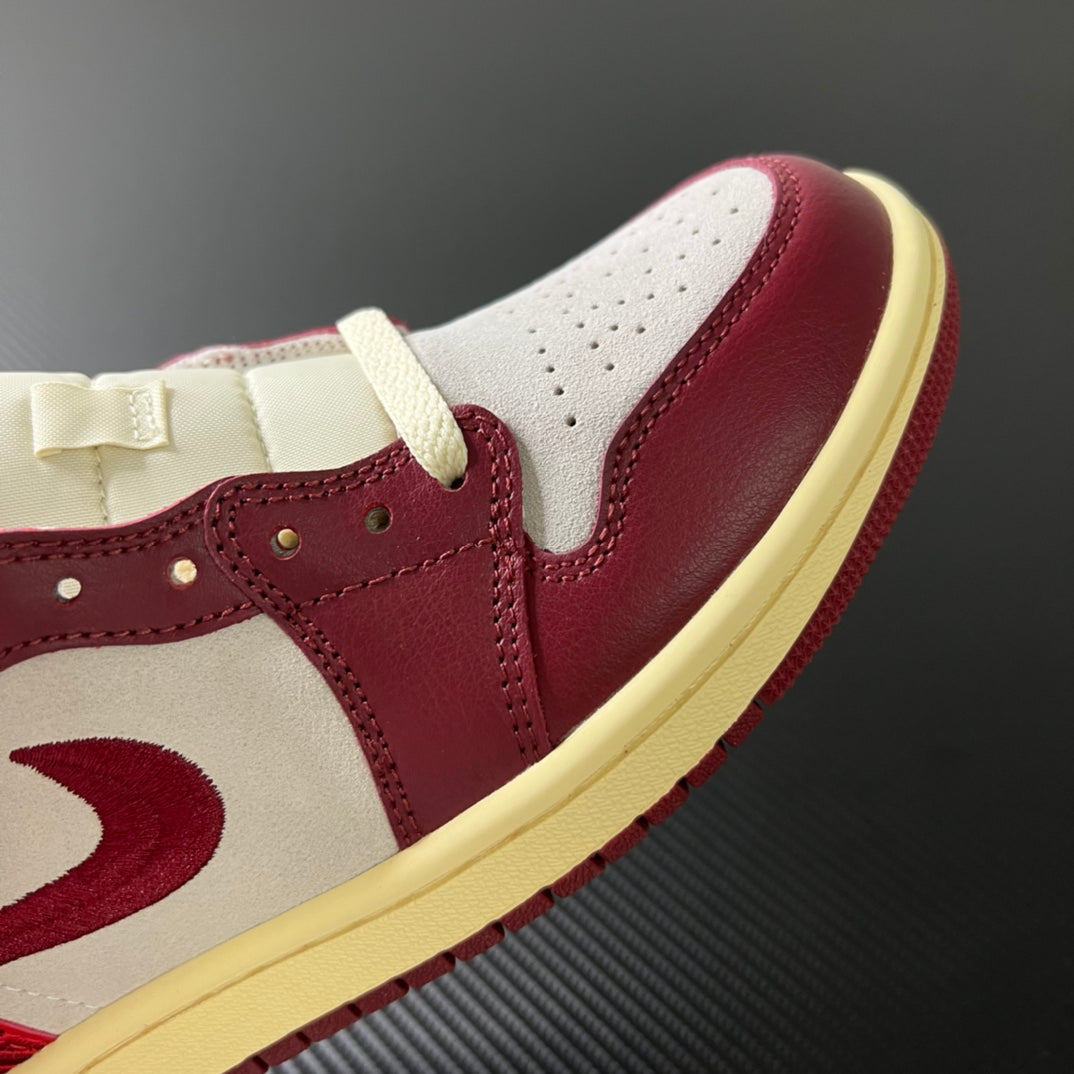 Side view of mid-top sneakers in white and burgundy with beige outsole and lace panel